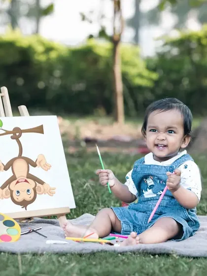 Such a cheeky and happy expression. This little boy is having a great time with his paintbrushes during his first birthday 'Little Artist' photoshoot.