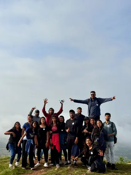 A big group photo at the summit of Uttari Betta, celebrating a successful sunrise trek together.