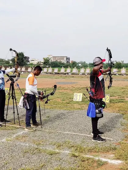 A line of compound bow archers taking aim at the state competition. Each athlete is in their own zone, focused solely on their target.