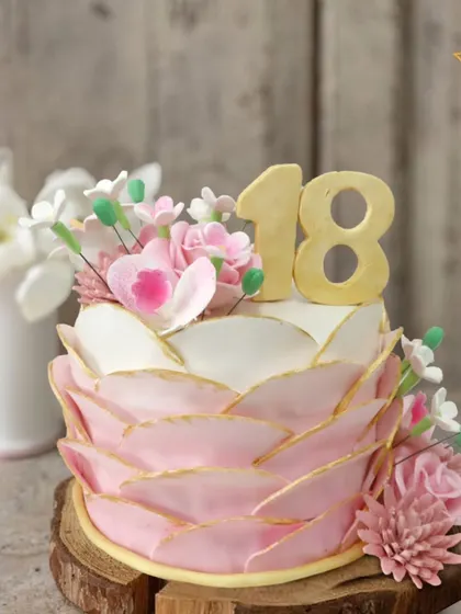 Celebrating Ishita's 18th birthday in Rajouri Garden with this stunning floral cake. The pink petal-like design and fresh blooms symbolize a beautiful new chapter, making it a perfect sweet 18 cake.