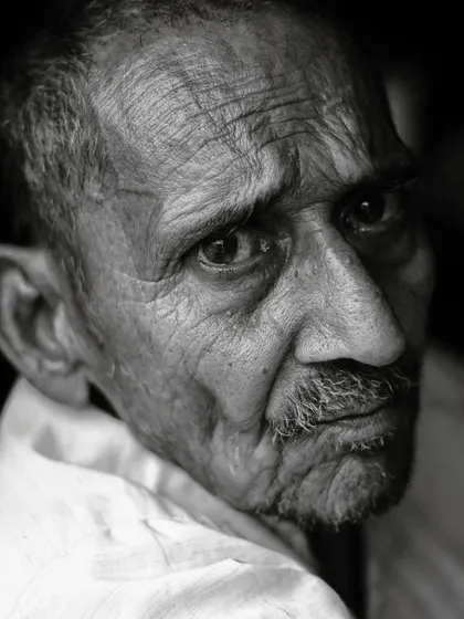 I find that a person's eyes can convey so much without a single word. This close-up, black and white portrait captures the deep emotion and contemplative look of an elderly man, with the shadows emphasizing the lines and character of his face.