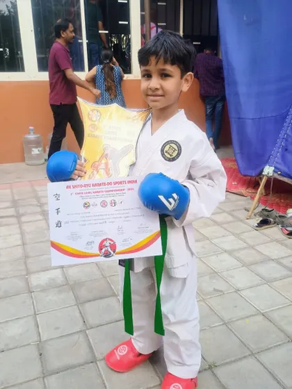 A young champion proudly holds his certificate and trophy. This victory is a result of countless hours of practice and unwavering focus.