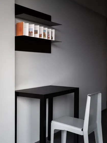 A minimalist study corner featuring a sleek black desk made of bent metal. I design furniture for all types of spaces, and this simple, clean-lined desk is perfect for a small, modern workspace.