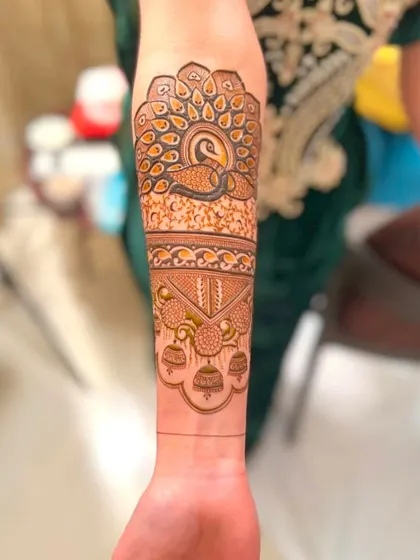 A close-up of an arm design featuring a large, beautifully detailed peacock.