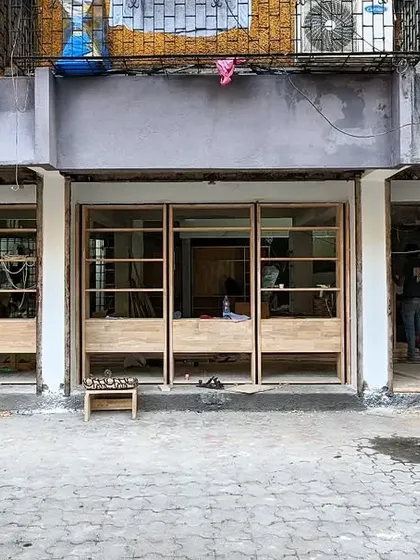 The facade during construction, showing the contrast between the new, clean woodwork and the yet-to-be-finished sections.