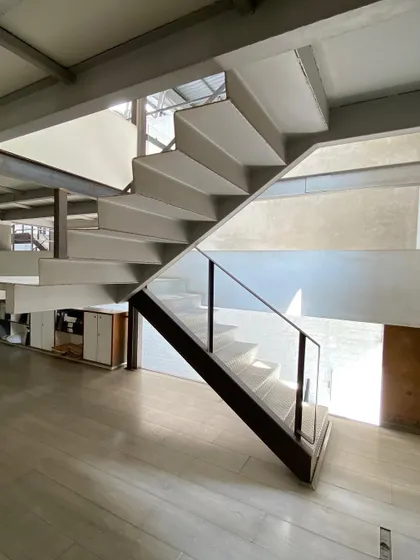A different view of the staircase at Zanav Home, showing how it connects different levels of the open-plan studio.