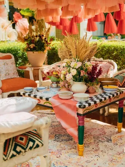 A regal lounge setup under an embroidered tent, with hand-painted furniture and rich textiles creating a luxurious and comfortable space.