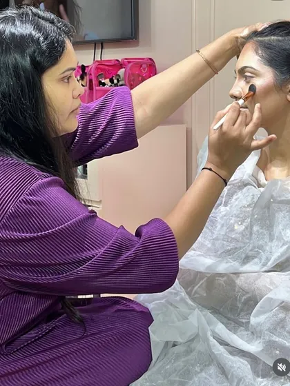 A student from my professional batch carefully applies contour. I teach them how to sculpt the face subtly to enhance the model's natural bone structure.