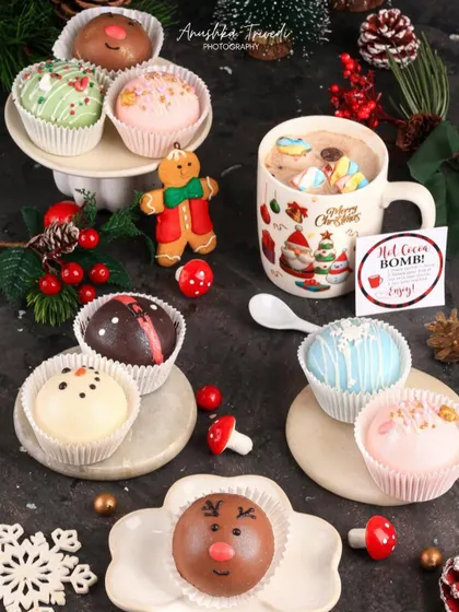 The hot cocoa bombs are styled with a Christmas mug and a gingerbread man, creating a cozy and inviting holiday scene.