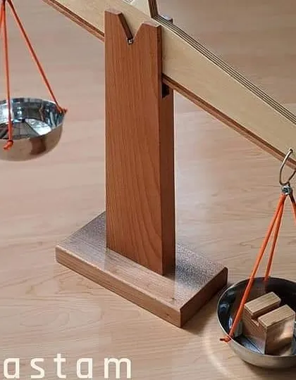 This simple wooden weighing scale is a practical life and math tool. Children can experiment with it to gain an intuitive understanding of weight, balance, and measurement.