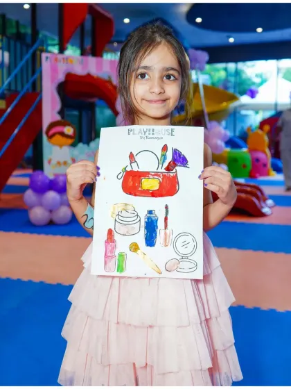 A proud artist showing off her work. Coloring activities that match the party's theme, like this makeup-themed sheet for our Mani-Pedi party, are always a hit.