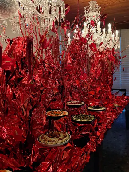 The full view of the artistic red food table, a bold and unconventional way to present a meal.