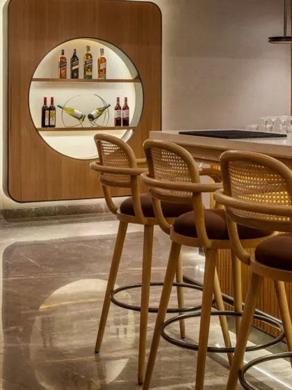 A detail of the bar seating, where modern design meets classic materials. The bar stools feature woven cane backs, aligning with the resort's nature-inspired theme while providing comfortable and stylish seating for guests.