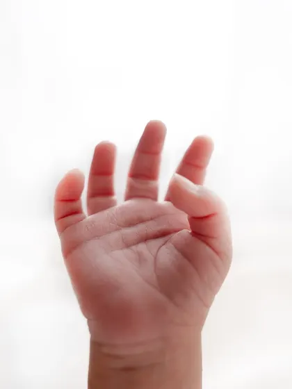 A tiny, perfect hand reaching out. I focus on capturing these small but significant details during my newborn photography sessions.