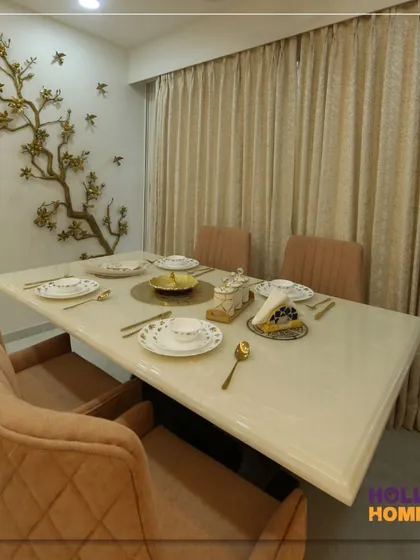 The dining area in our Thane project features a beautiful marble-top table and a stunning metal wall art piece depicting a tree, adding a touch of nature indoors.