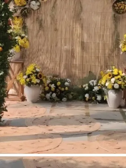 A rustic and enchanting photobooth. The backdrop is made of natural bamboo mats, adorned with yellow flowers and jute rugs, creating a perfect spot for pictures.