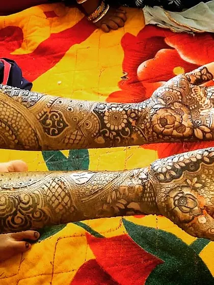 A full view of a completed bridal mehendi, showing the design from fingertips to mid-forearm. The mix of floral and geometric patterns provides a balanced and intricate look.