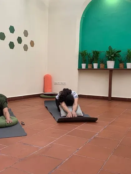 Participants using bolsters and pillows to find comfort and depth in a forward fold. My classes emphasize using props to support the body, allowing for a deeper release and relaxation.