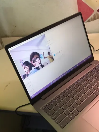 A laptop screen displays a Python application that uses AI to apply virtual filters and effects to a person's face in real-time.