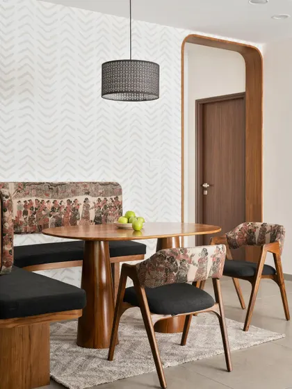 We created this cozy dining nook for the 'Palaash' project with a custom curved wall, built-in seating, and bold tribal-print upholstery. It’s a perfect example of how we carve out intimate spaces.