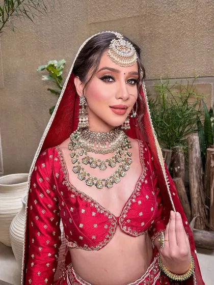 The bride adjusts her veil, a classic and timeless bridal pose that is full of grace.