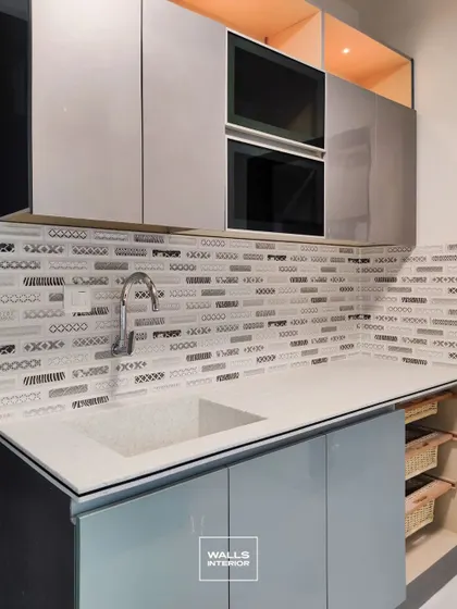 A close-up of the textured mosaic backsplash and the glossy finish of the handleless cabinets, showcasing our attention to material details.