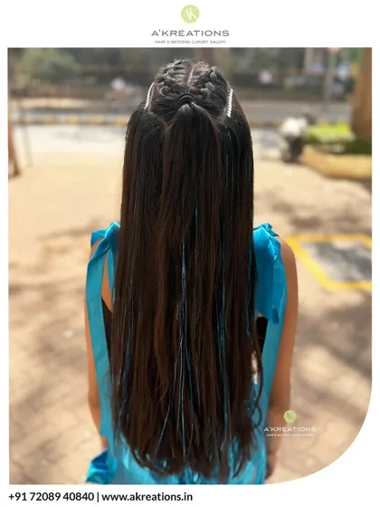 The back view of this cool braided look, showing how the braids transition into a long, sleek ponytail with fun blue tinsel extensions.