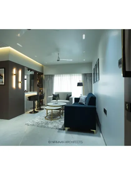 Another perspective of the Tulsi Heights living room, emphasizing the clean lines and the balance between the dark partition and the light-filled seating area.