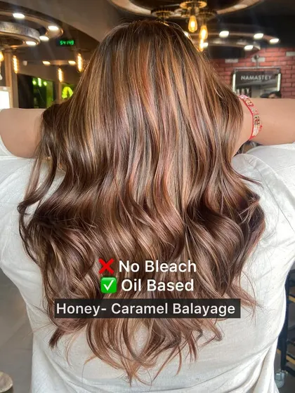 This image clearly shows the oil-based, no-bleach technique used for this honey-caramel balayage, resulting in healthy, vibrant hair.