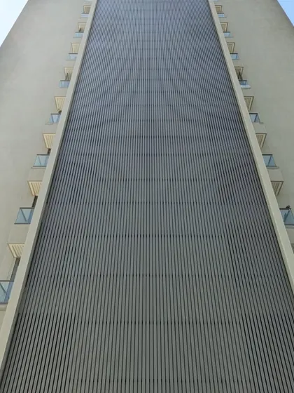 No project is too big. Here you can see a massive residential tower featuring our custom vertical metal louvers, creating a stunning visual texture and providing functional shading for the entire building facade.
