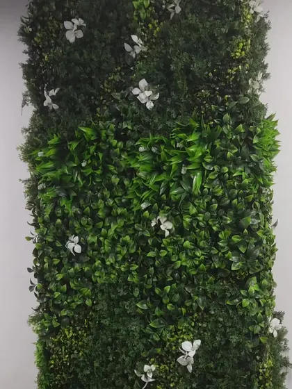 An example of a simple but elegant green wall panel. This design features a base of dark green foliage with small white flowers scattered throughout, suitable for a clean and professional office environment.