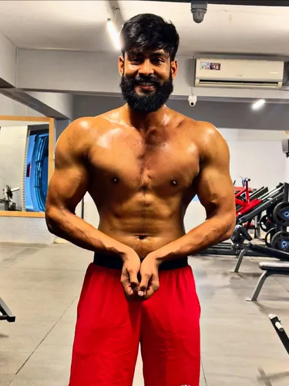 A front-facing physique pose, showing the chest, abs, and arm development.