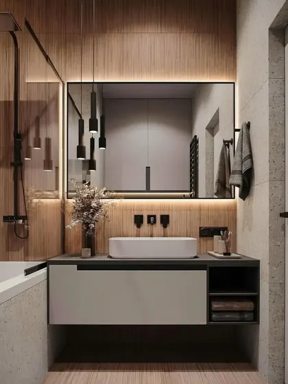 This bathroom combines concrete-finish tiles with wood accents for a modern industrial look. The black fixtures and pendant lights add a bold, graphic element to the design.