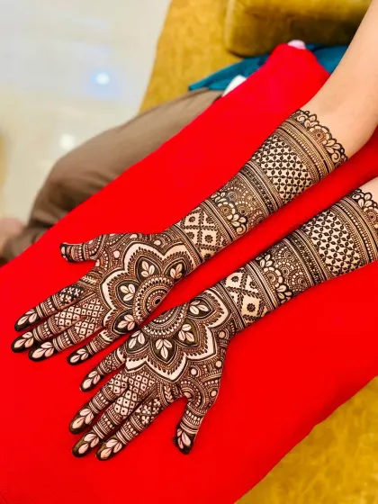A classic full-hand bridal design featuring symmetrical mandalas on the palms and detailed jaal work covering the arms. This is a popular choice for a traditional look.