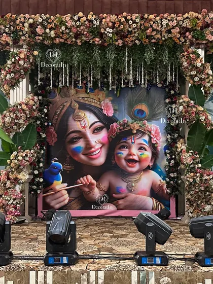 A stunning stage backdrop for a Krishna-themed baby shower, featuring a beautiful portrait of Yashoda and Krishna, framed by a lush floral arch.