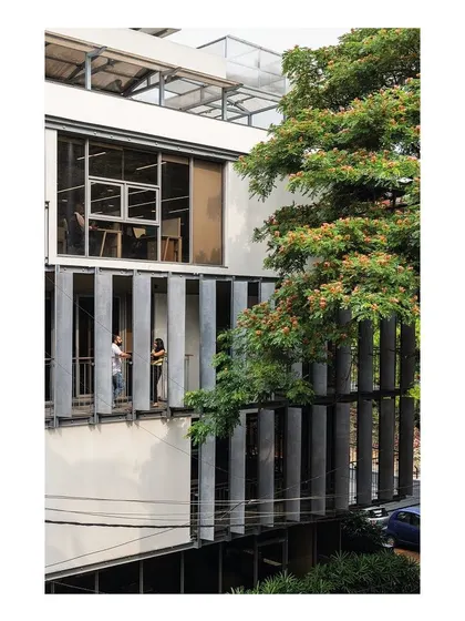 The staggered balconies create opportunities for informal interaction and provide employees with a direct connection to the outdoors. The vertical concrete fins offer privacy and solar shading without obstructing the views of the surrounding trees.