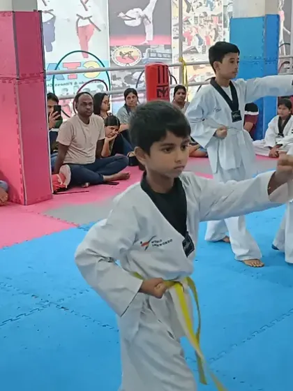 Young yellow belts practicing their first form in front of an audience of parents.