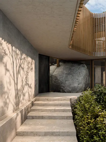 The entrance to the Lurra House in Hyderabad is defined by a massive, natural boulder. This render shows our concept of building around and with the landscape, making the earth itself a fundamental part of the architectural experience.