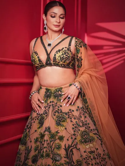 A soft and elegant pose, with Tanishaa looking down. This shot emphasizes the stunning necklace and the detailed embroidery on the blouse.