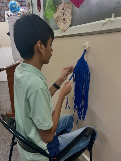 From another angle, you can see the student's dedication to his macrame piece. The progress he's made is a testament to his focus and hard work.