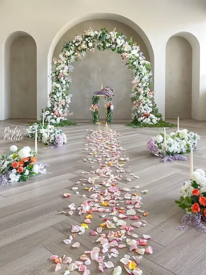 A stunningly romantic indoor aisle. The floral arch and petal-strewn path create a magical walkway, perfect for a proposal or an intimate ceremony.