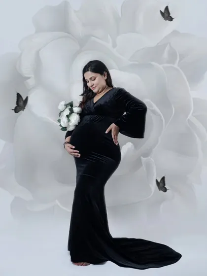 Simple, elegant, and powerful. In our studio, we create a peaceful space for you to just be. This black gown against the artistic floral backdrop is a classic look that focuses on the beautiful shape of your baby bump.