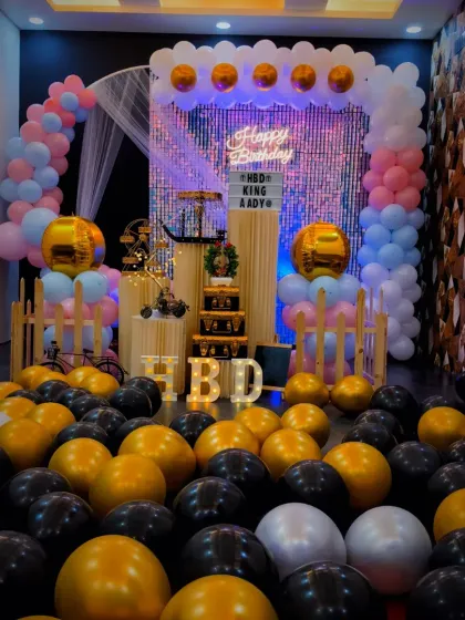A closer view of the pastel and gold birthday decorations. You can see the "HBD" light-up letters, which add a personal and bright touch to the party decor.