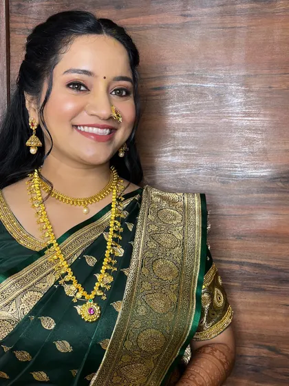 A full-length shot showing her beautiful green engagement saree and the soft, wavy hairstyle.
