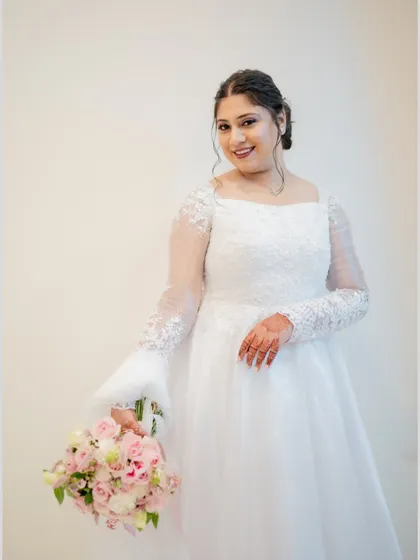 A beautiful three-quarter portrait of the bride in her elegant white gown, holding her bouquet.