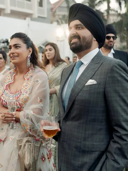 A candid photo of me and my husband at a wedding. My embroidered Anamika Khanna outfit and his sharp suit show how to coordinate for a formal event.