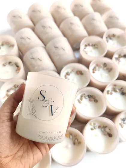 Frosted jar candles with an 'SV' monogram, topped with seashells for an Ocean Breeze scented wedding favor.
