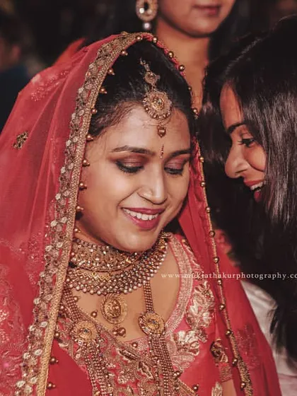 A bride sharing a happy, secret moment with her friend during the wedding festivities. It's these personal interactions that add so much warmth to the wedding album.