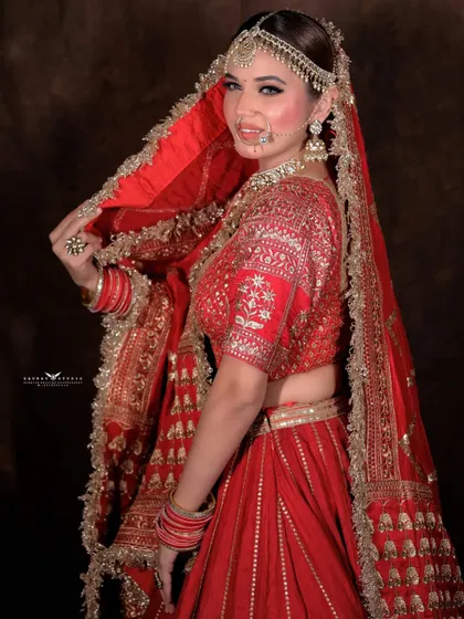 A classic over-the-shoulder pose. The bride looks back with a smile, showing off the back details of her blouse and the flow of her dupatta.