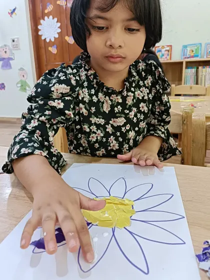 This camper is deeply engaged in her paper mosaic project. Art activities like this help improve concentration and attention to detail.